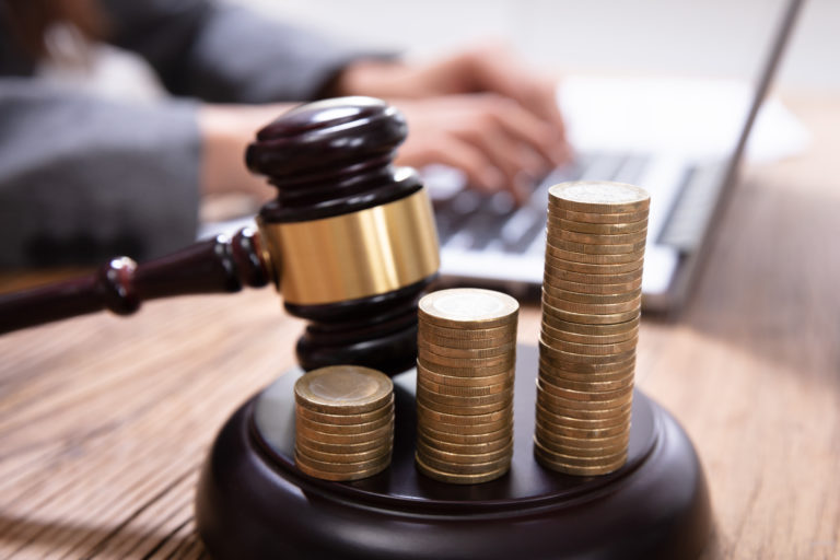 Stack Of Increasing Coins On Gavel At Workplace